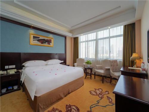 Una habitación de hotel con una cama grande y un escritorio. en Vienna Hotel Shanghai Pudong Jinqiao Park, en Shanghái