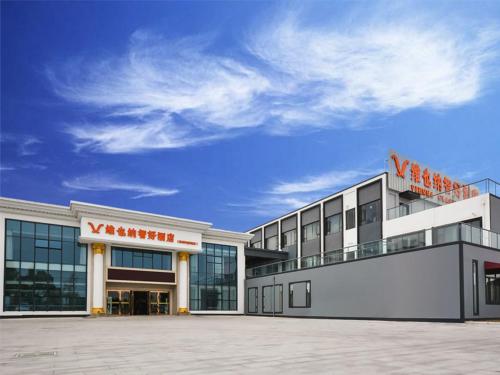 un grand bâtiment avec un panneau d'avant-garde au sommet dans l'établissement Vienna Hotel Suzhou Yangcheng Lake Huayi Movie World, à Zhengyi