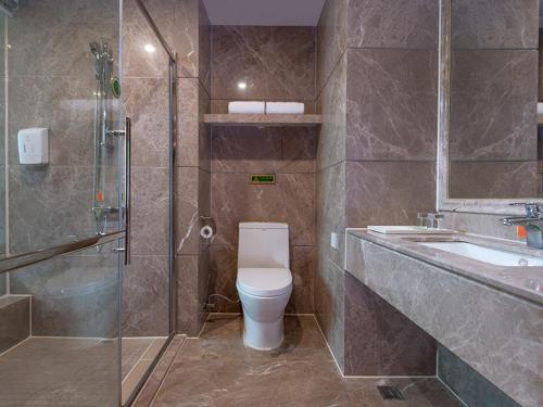 NanhaiにあるVienna International Hotel Guangzhou Jiaokou Subway Stationのトイレ、シャワー、洗面台を備えたバスルーム