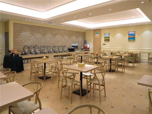 un restaurante con mesas y sillas en una habitación en Vienna International Hotel Xian High Technology Road en Xi'an
