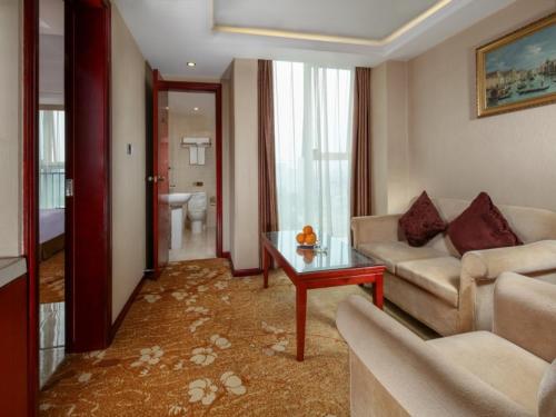 a living room with a couch and a table at Vienna Hotel Chengdu Exhibition Centre in Chengdu