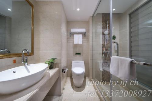 a bathroom with a sink and a toilet and a shower at Vienna 3 good hotel (Anhui Ningguo store) in Ningguo