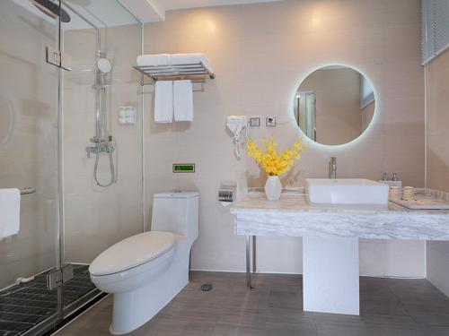 a bathroom with a toilet and a sink and a mirror at Vienna 3 Best Hotel Beihai Sichuan Road in Beihai