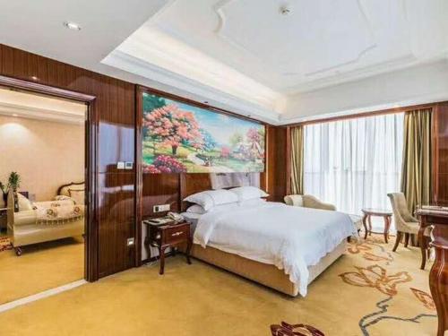 een slaapkamer met een bed en een groot schilderij aan de muur bij Vienna Hotel Foshan Lecong Centre in Shunde