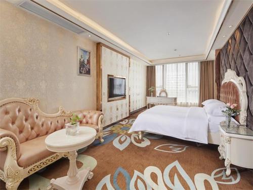 a bedroom with a large bed and a couch at Vienna Classic Hotel Dongguan Changan Xiandai in Dongguan