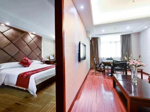 a hotel room with a bed and a dining room at Vienna Hotel Nanning Jiangnan Wanda in Nanning