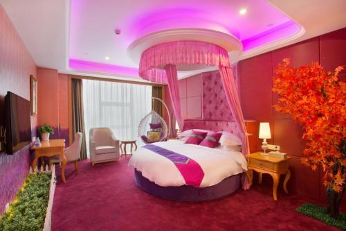 ein Schlafzimmer mit einem großen Bett und einer violetten Decke in der Unterkunft Vienna International Hotel Changsha Hongxing in Changsha