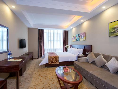 a hotel room with a couch and a bed at Vienna Classic Hotel Guangzhou Yanling Road in Guangzhou