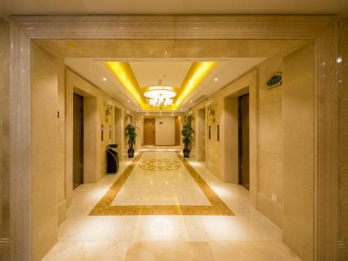 a hallway of a building with a large rug at Vienna Hotel Kunshan North Qingyang Road in Kunshan