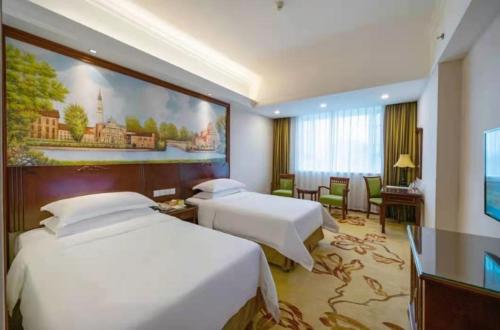 Postel nebo postele na pokoji v ubytování Vienna International Hotel Dongguan Liaobu