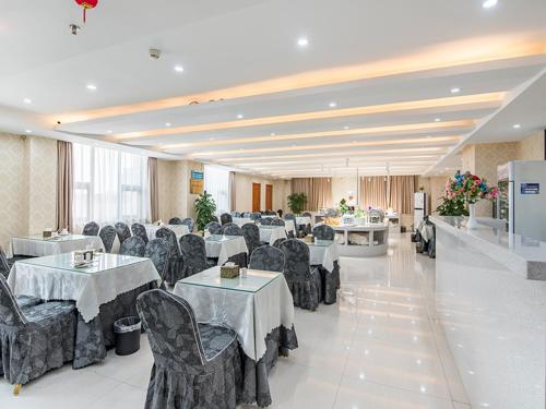 una sala per banchetti con tavoli e sedie in una stanza di Vienna Hotel Zhengzhou Airport a Zhengzhou