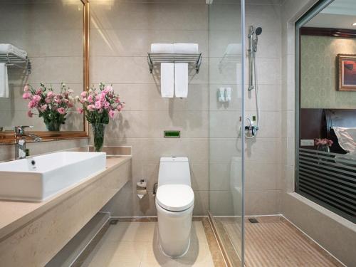 La salle de bains est pourvue de toilettes, d'un lavabo et d'une douche. dans l'établissement Vienna International Hotel Zhongshan Shiqi Kanghua Road, à Zhongshan