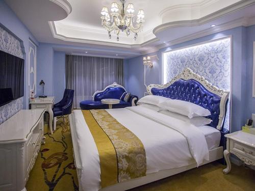 a bedroom with a large bed and a chandelier at Vienna Hotel Chengdu Dafeng Subway Station in Chengdu