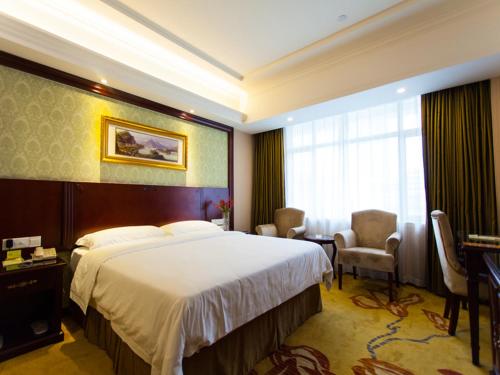 a hotel room with a large bed and a window at Vienna Hotel Guangzhou Jinshazhou in Nanhai