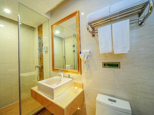 uma casa de banho com um lavatório, um WC e um chuveiro em Vienna Hotel Shenzhen Nanxin Road em Shenzhen