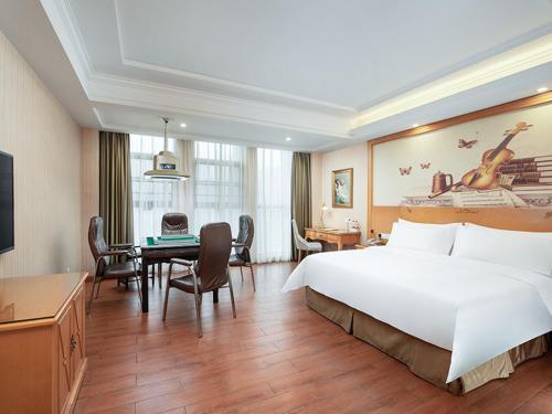 a large hotel room with a large bed and a desk at Vienna Hotel Hunan Xincheng Guoji in Liuyang