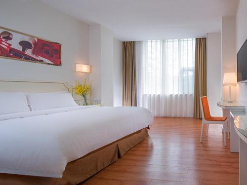 a hotel room with a large bed and a desk at Vienna 3 Best Hotel Shenzhen Shazui Road in Shenzhen