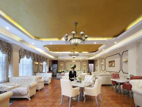 a man in a restaurant with tables and chairs at Vienna Hotel Nanjing Baijiahu Ximenzi in Nanjing