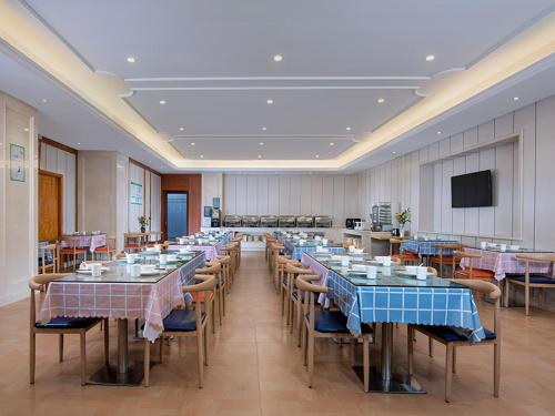 a large room with tables and chairs and a television at Vienna International Hotel Zhuhai Golden Phoenix in Zhuhai