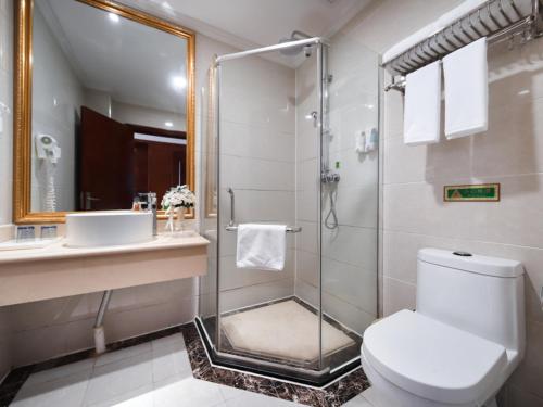 a bathroom with a shower and a toilet and a sink at Vienna Classic Hotel Nanchang Jiefang West Road in Nanchang