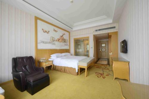 a hotel room with a bed and a chair at Vienna International Hotel Shanghai Malu Station in Jiading