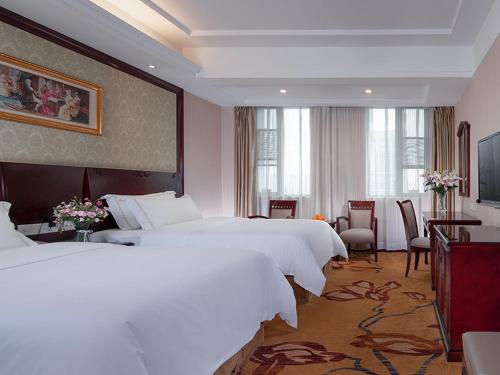 a hotel room with two beds and a living room at Vienna Hotel Guiyang Exhibition Center in Guiyang