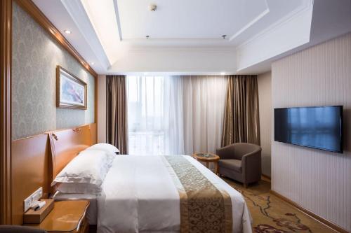 una camera con letto e TV a schermo piatto di Vienna Hotel Jiangsu Changzhou Qingfeng Park a Changzhou