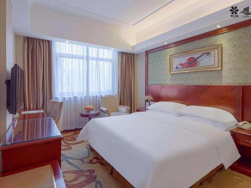 a hotel room with a large bed and a window at Vienna Hotel Changsha Mid Furong Road in Changsha