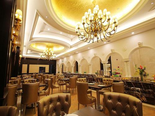 a restaurant with tables and chairs and a chandelier at Vienna Hotel Waigaoqiao in Shanghai