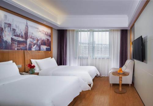 Vienna 3 Best Hotel (Ganzhou shangyou store) في Yuanzicha: غرفة فندقية بسريرين وتلفزيون بشاشة مسطحة