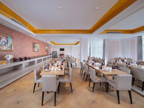 a dining room with tables and chairs in a restaurant at vienna Hotel (fujian quanzhou dehua station) in Dehua