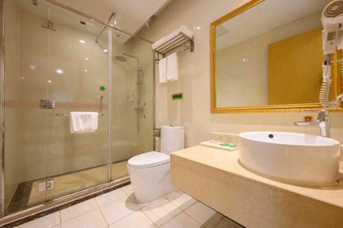 a bathroom with a toilet and a sink and a shower at Vienna International Hotel Shanghai Malu Station in Jiading