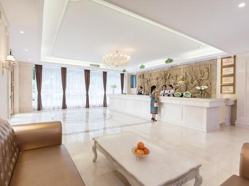 a child standing in a living room with a counter at Vienna Hotel Nanning Qingxiu Mountain in Nanning