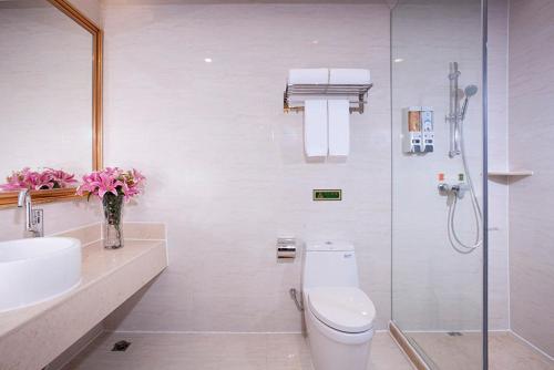a bathroom with a toilet and a sink and a shower at Vienna International Hotel Puning International Commodity City in Puning