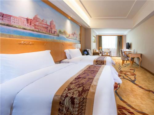 a hotel room with two beds and a painting on the wall at Vienna International Hotel (Shen Zhen Buji Dafen shop) in Shenzhen