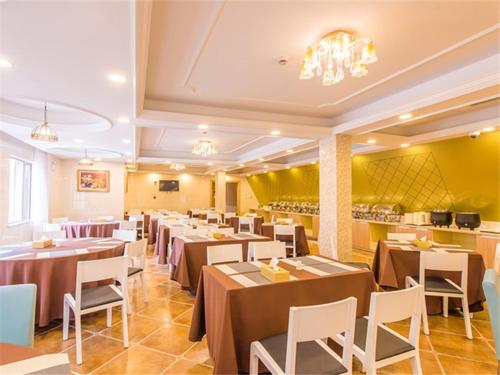 a dining room with tables and chairs and a chandelier at Vienna International Hotel Shanghai Jinqiao Industrial Park North Yanggao Road in Shanghai