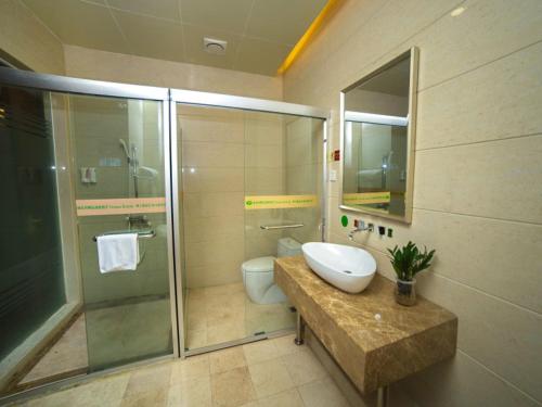 a bathroom with a sink and a toilet and a shower at Vienna Hotel Lufeng Peopole Road in Lufeng