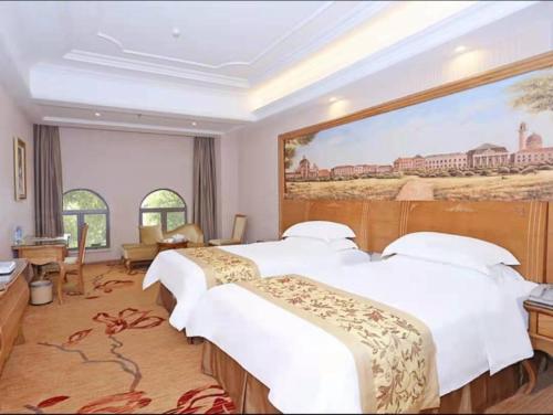 Vienna Hotel Shantou Longhu South Taishan Road في شانتو: غرفة فندقية بسريرين ولوحة على الحائط