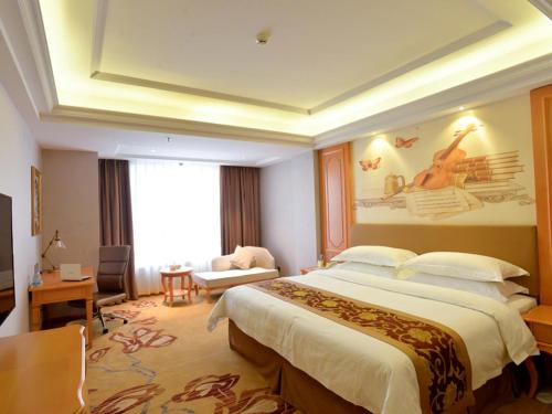 a bedroom with a large bed in a hotel room at Vienna Hotel Shantou Chaoyang Mianxi Road in Shantou