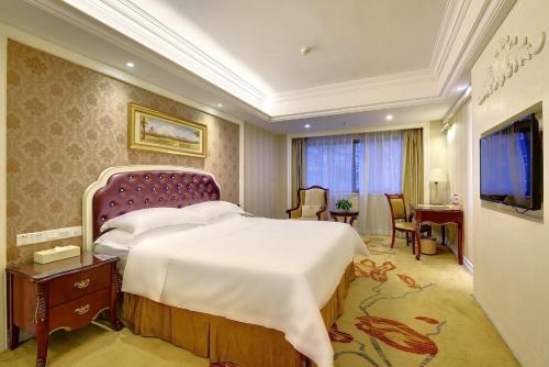 a hotel room with a large bed and a desk at Vienna International Hotel Nanning Zoo in Nanning
