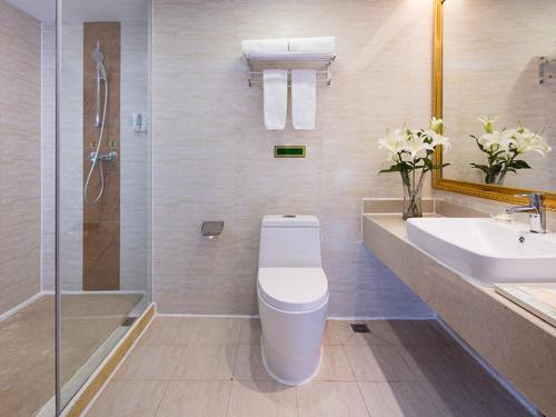 W łazience znajduje się toaleta, umywalka i prysznic. w obiekcie Vienna International Hotel Zhongshan Torch Development Zone w mieście Zhongshan