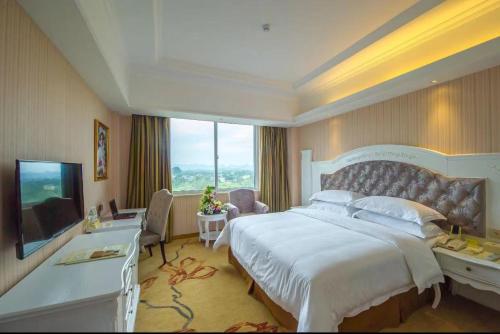 a bedroom with a large bed and a large window at Vienna International Hotel Guilin Wanda Plaza in Guilin