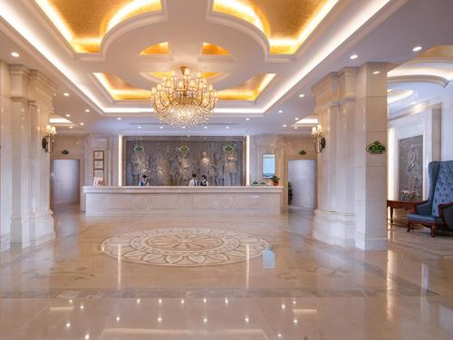 une grande chambre avec un lustre et un grand hall dans l'établissement Vienna International Hotel Shenzhen Dameisha, à Shenzhen