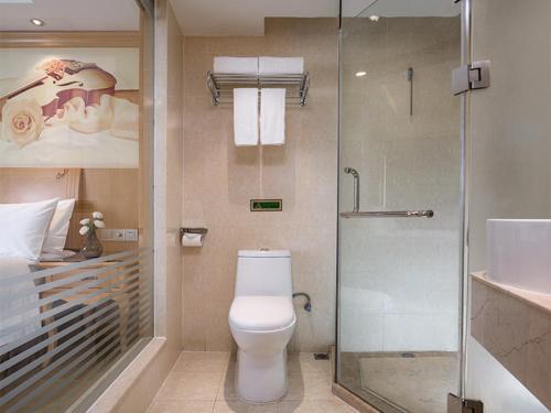 a bathroom with a toilet and a glass shower at Vienna 3 Best Hotel Guangxi Nanning Station in Nanning
