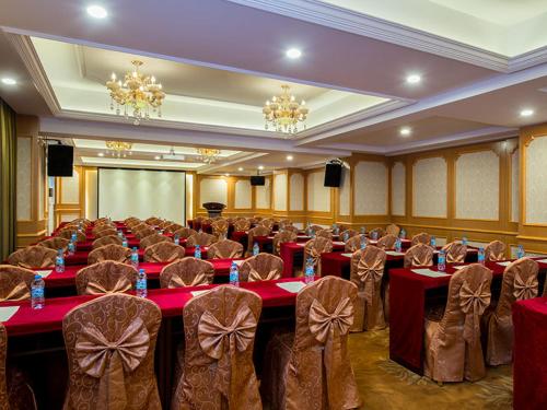 a banquet hall with red tables and chairs and chandeliers at Vienna Hotel Foshan Lingnan Pearl Gymnasium Branch in Foshan