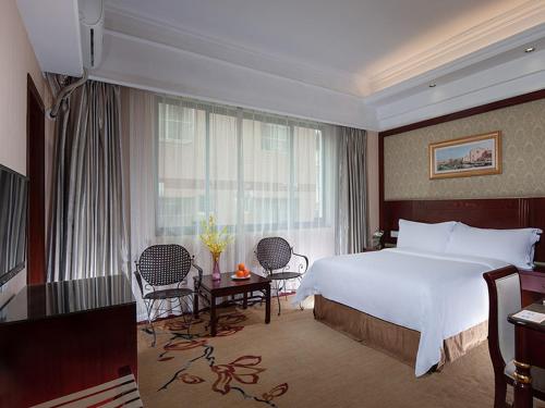 a hotel room with a bed and a table and chairs at Vienna Hotel Nanning Changhu Road in Nanning