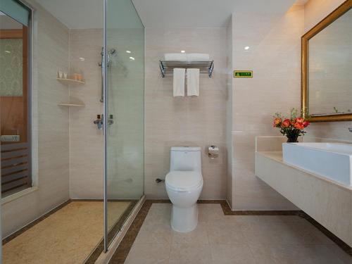 uma casa de banho com um WC, um chuveiro e um lavatório. em Vienna International Hotel Lijiang Yuxue Avenue em Lijiang