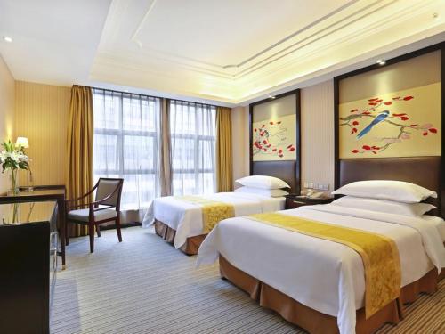 Vienna Hotel Changsha Gaoxin Lugu Park في تشانغشا: غرفة فندقية بسريرين ومكتب