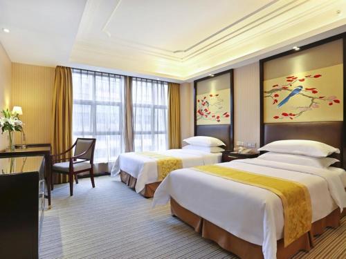Una habitación de hotel con dos camas y un escritorio. en Vienna Hotel Changsha Gaoxin Lugu Park, en Changsha