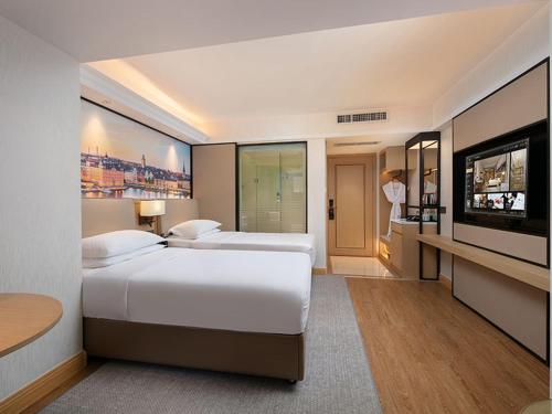 a hotel room with two beds and a flat screen tv at Vienna International Hotel Changsha Furong Plaza in Changsha